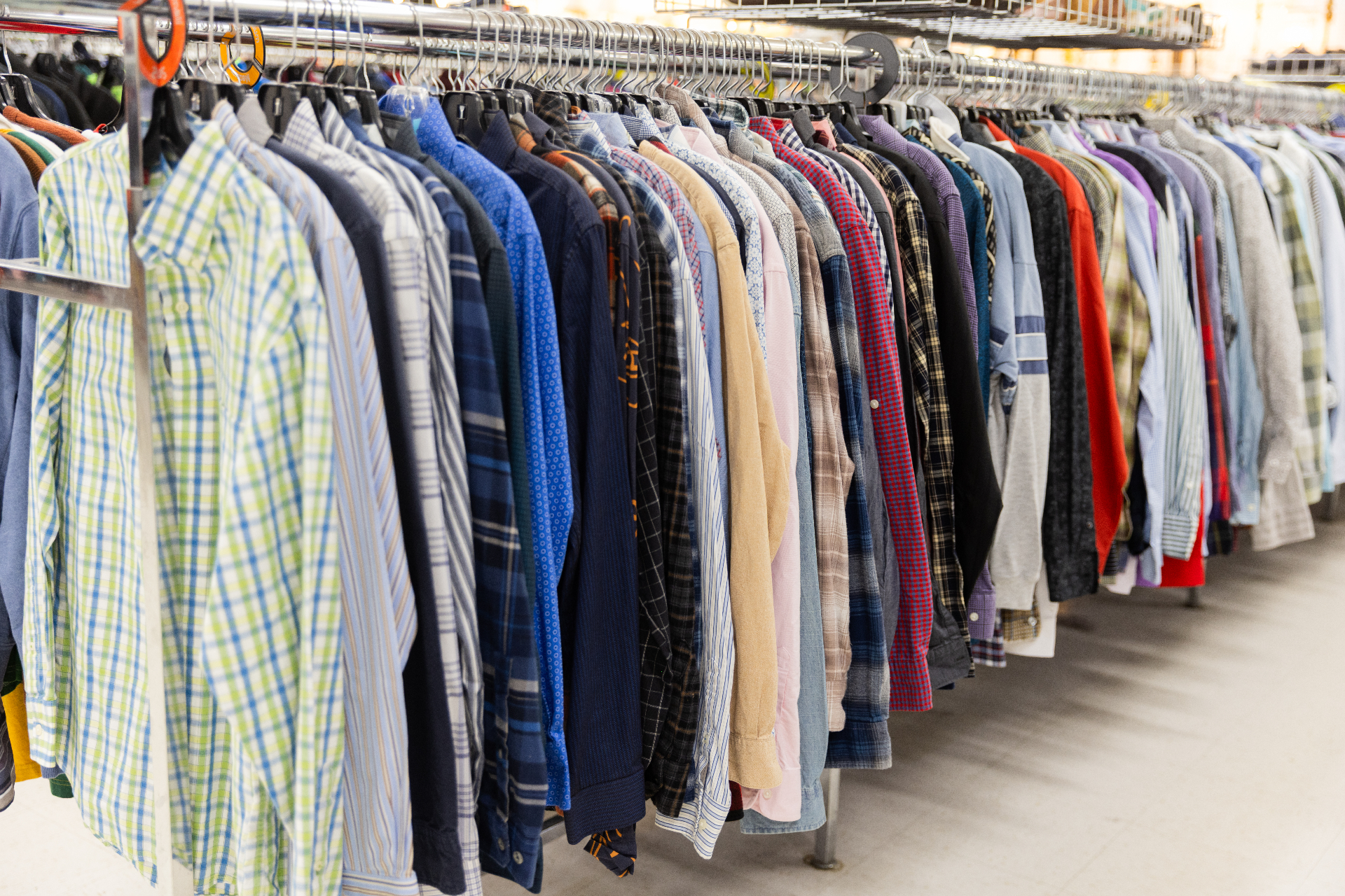 A long rack of button-down shirts on the sales floor of a City Thrift store in Kansas City